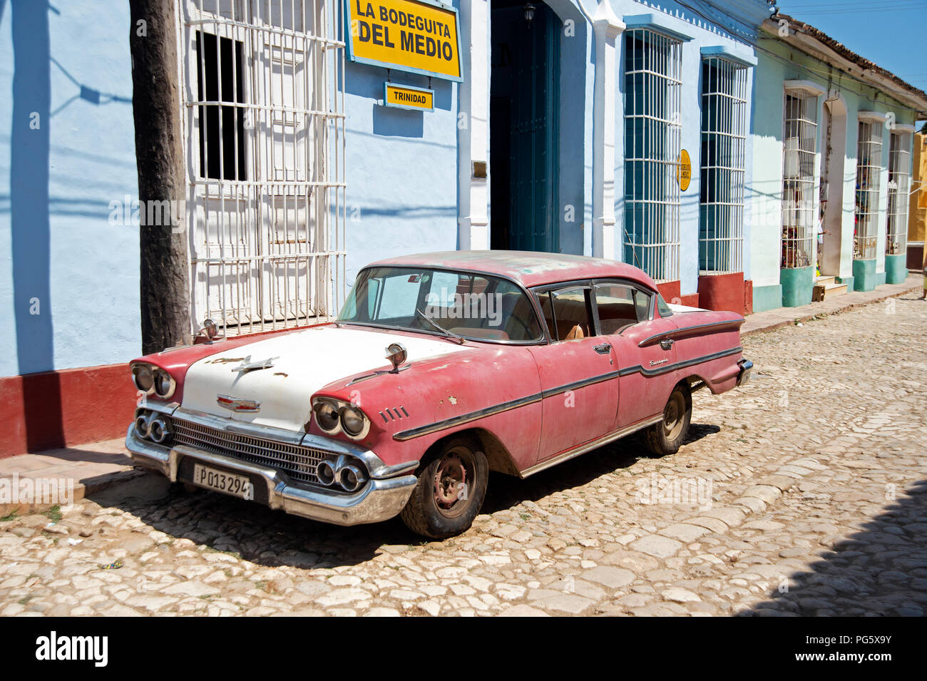Battere vecchio classico 1950 American automobile parcheggiata di fronte la Bodega del Medio in una strada a ciottoli in Trinidad, Cuba Foto Stock