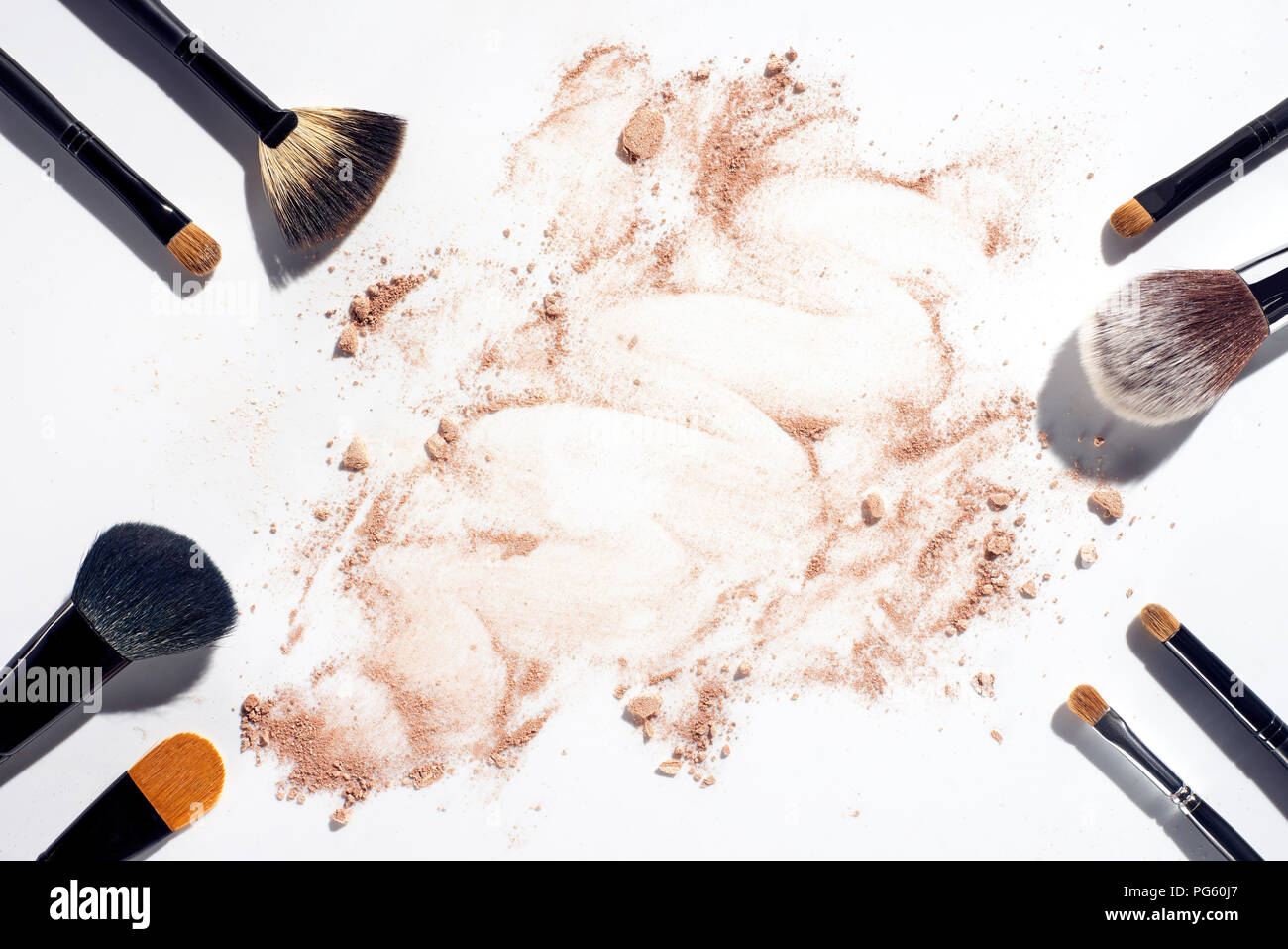 Telaio del make up pennelli su sfondo bianco con sparsi in polvere per il viso Foto Stock