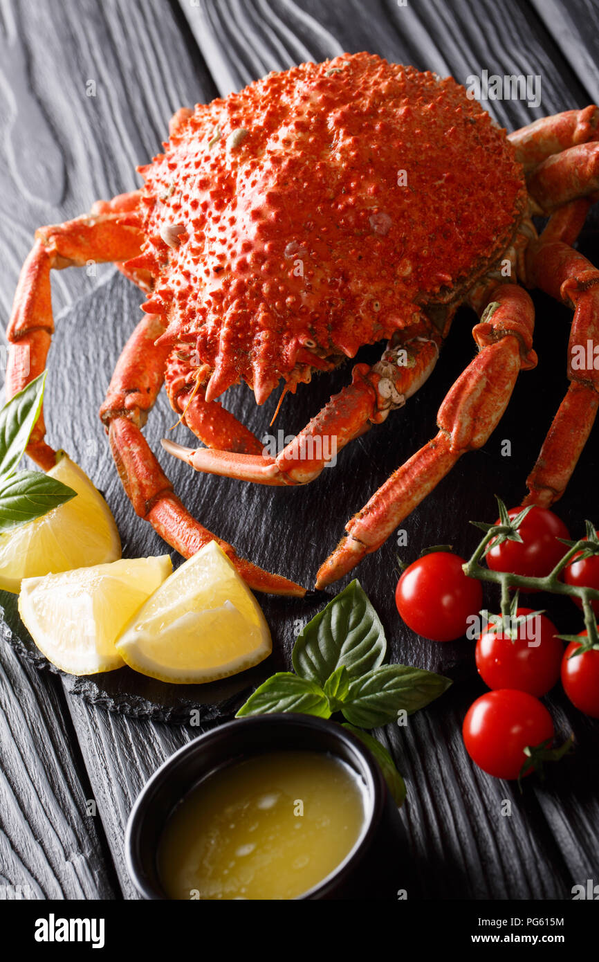 Delizioso il ragno granchio servita con il limone e il burro fuso vicino sul piano verticale. Foto Stock