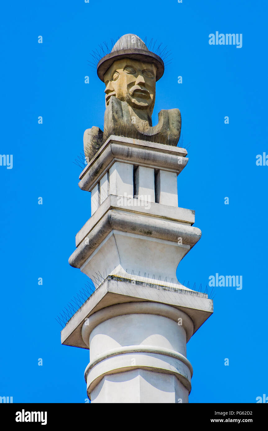 Una moderna statua di un il volto dell'uomo su un alto in pietra sulla colonna il municipio in stile rinascimentale di Poznan (Poznan), Polonia Foto Stock