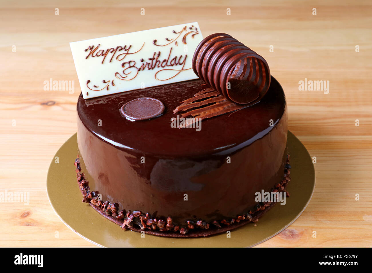 Mousse al cioccolato torta di compleanno guarnita con il cioccolato bianco greeting card sul tavolo di legno Foto Stock