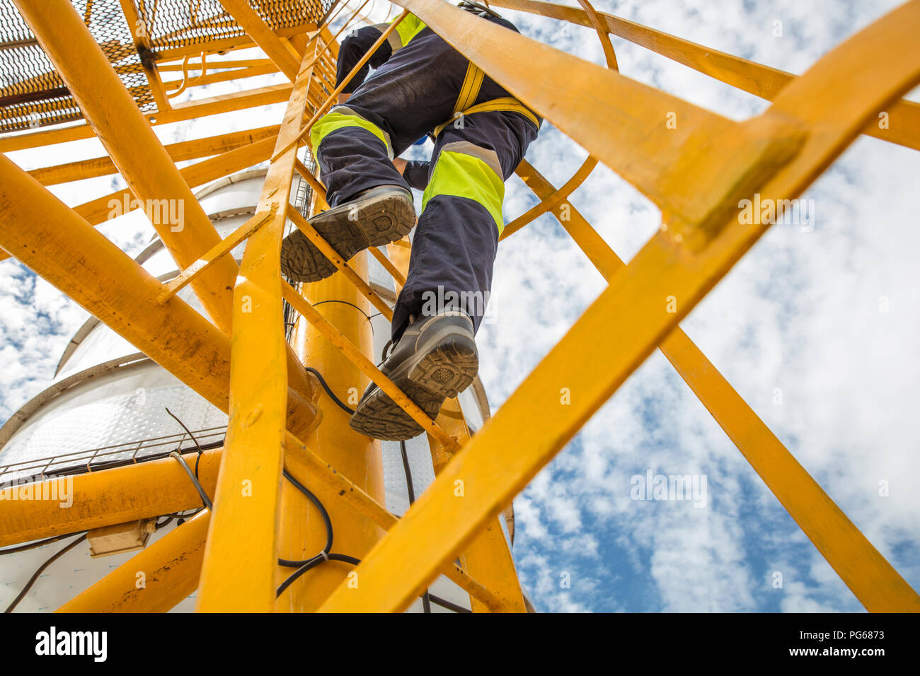 Lavoratore a salire la scala a serbatoio Foto Stock