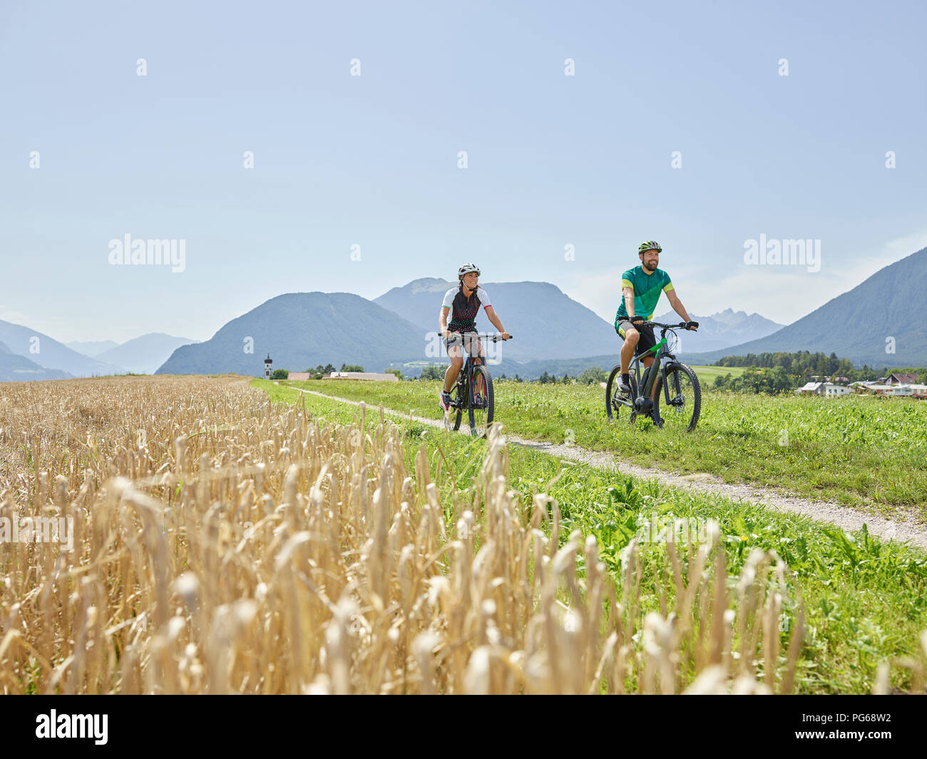 Austria, Tirolo, Mieming, giovane riding bike nel paesaggio alpino Foto Stock