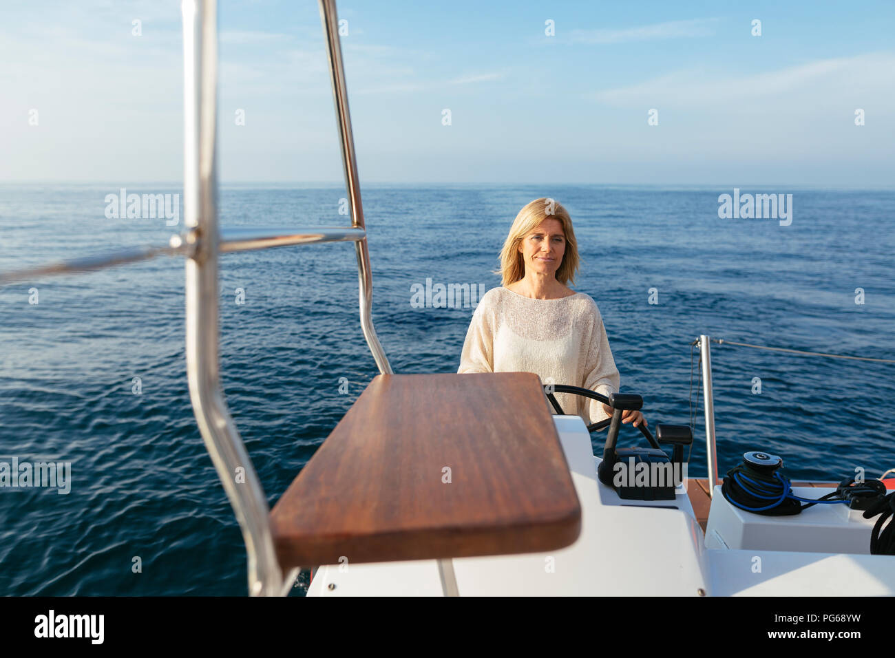 Donna matura navigazione in catamarano sul un viaggio in barca a vela Foto Stock