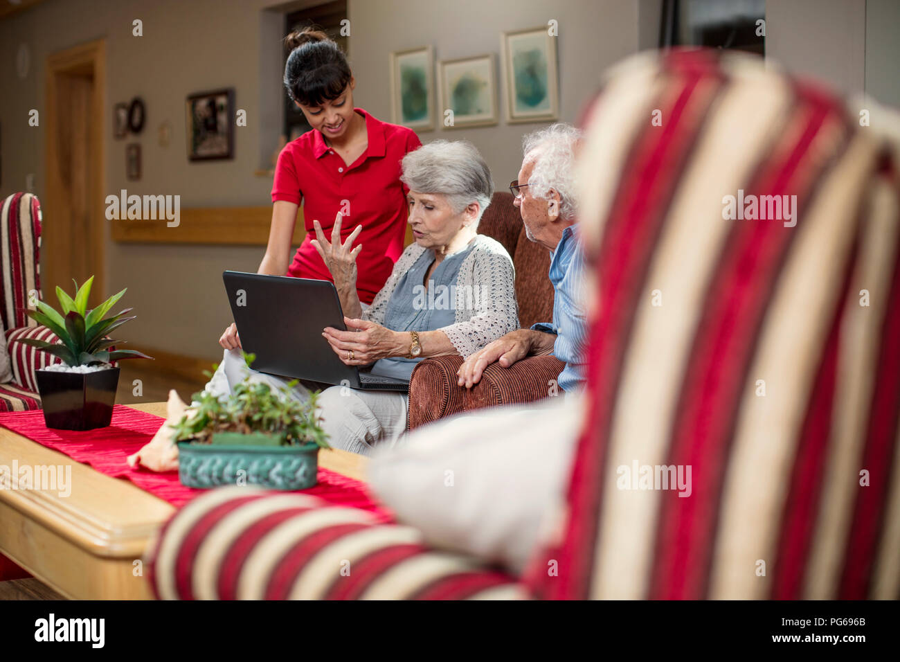 Seniors a casa di riposo guardando album di foto Foto Stock