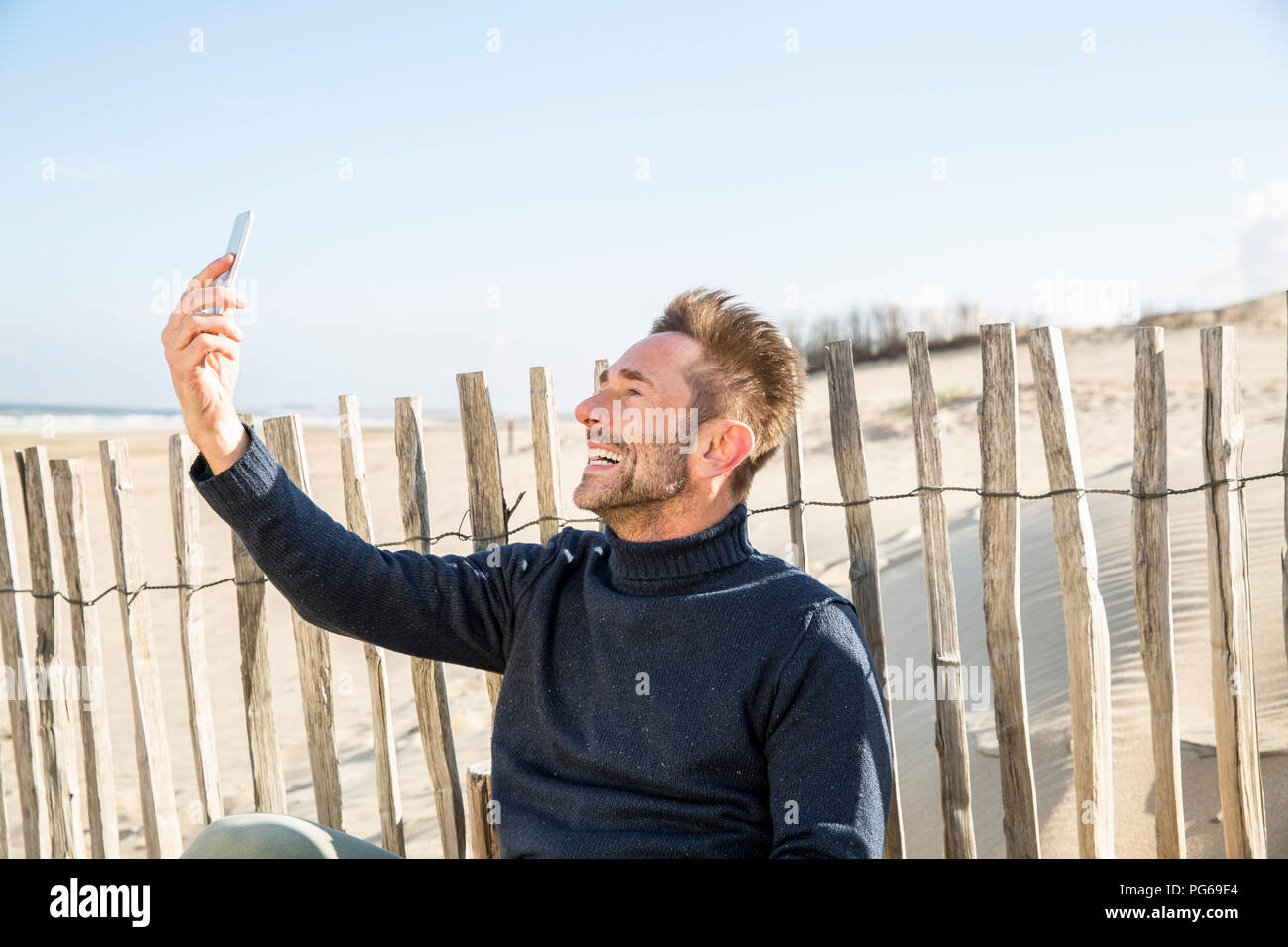 L'uomo prendendo un selfie sul righello sulla spiaggia Foto Stock