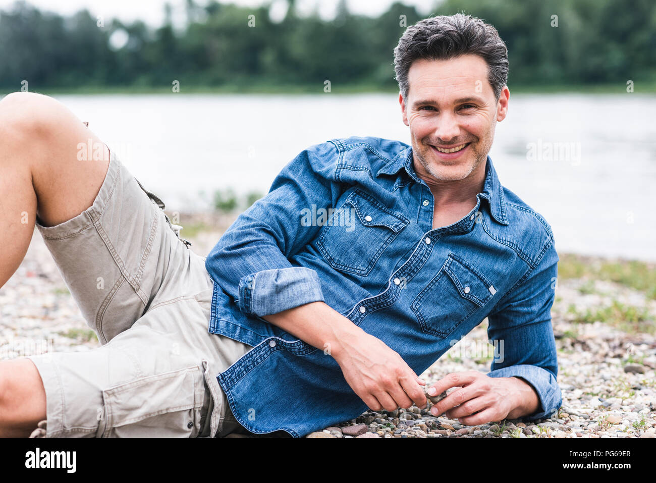 Ritratto di uomo sorridente di relax presso il Riverside Foto Stock