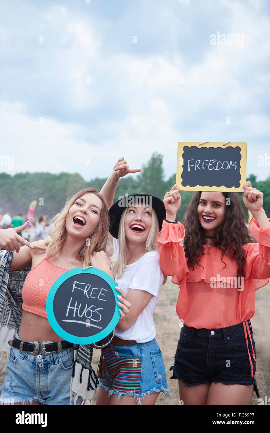 Felici donne presso il festival di musica con segni, free hugs, libertà Foto Stock