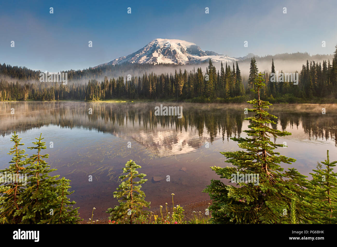 Mt Rainier e di riflessione sul lago con densa nebbia laminazione attraverso Foto Stock