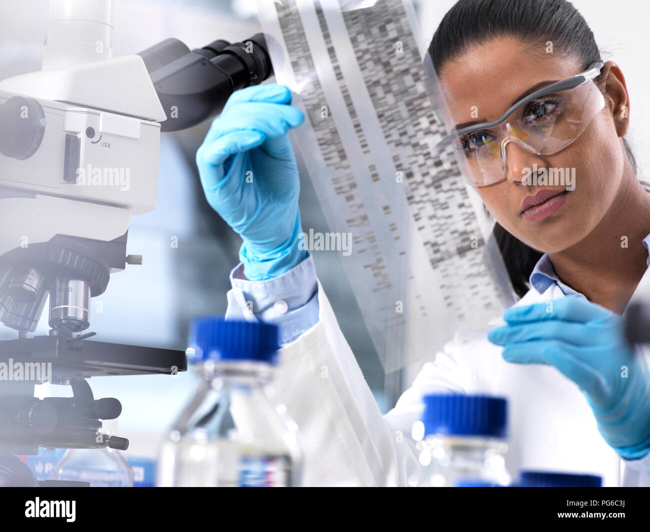 La ricerca genetica, donna scienziato tenendo un foglio con codice genetico, il make-up genetico Foto Stock