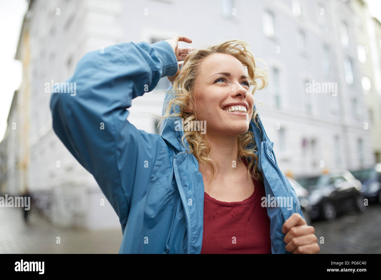 Ritratto di sorridere donna bionda mettendo sul suo cofano Foto Stock
