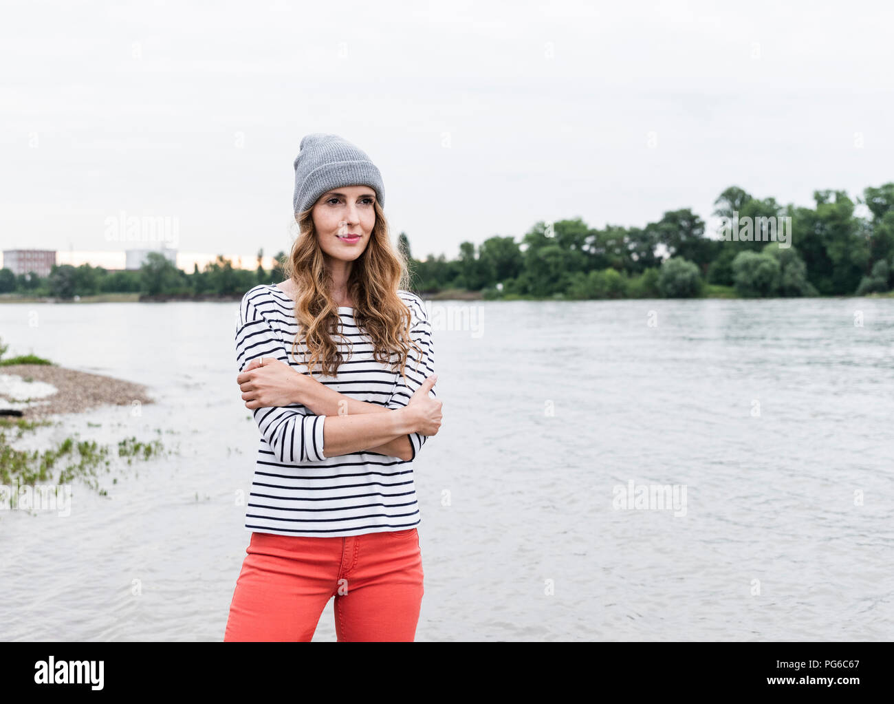 Ritratto di donna che indossa wooly hat permanente al Riverside Foto Stock