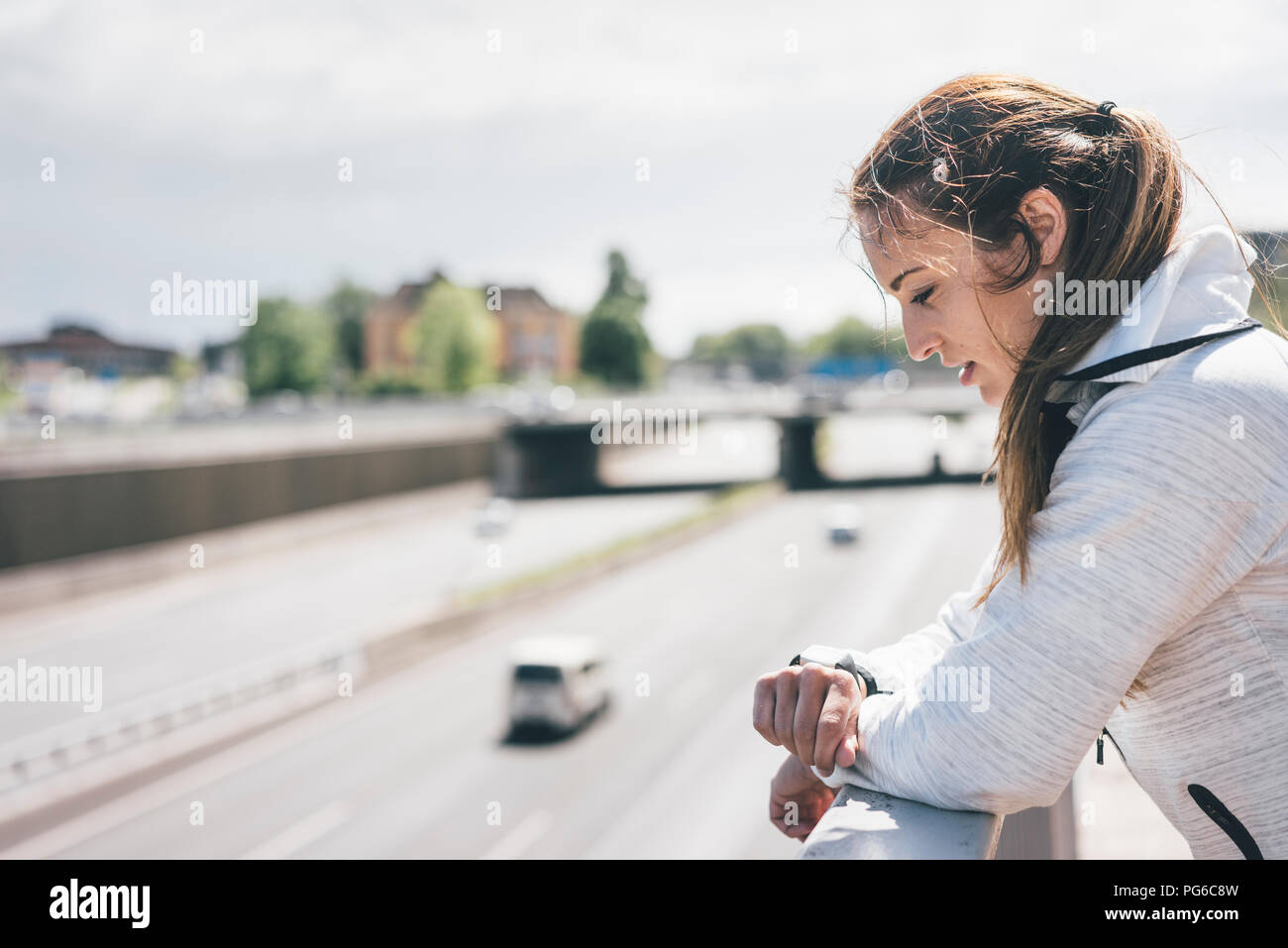 Attività sportive giovane donna cerca su guardare in autostrada Foto Stock