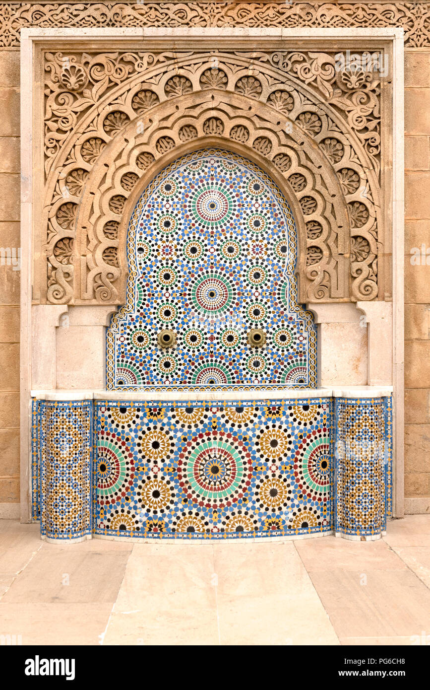 Complessamente fontana piastrellato con beccucci di ottone sul fuori della moschea Hassan a Rabat, Marocco Foto Stock