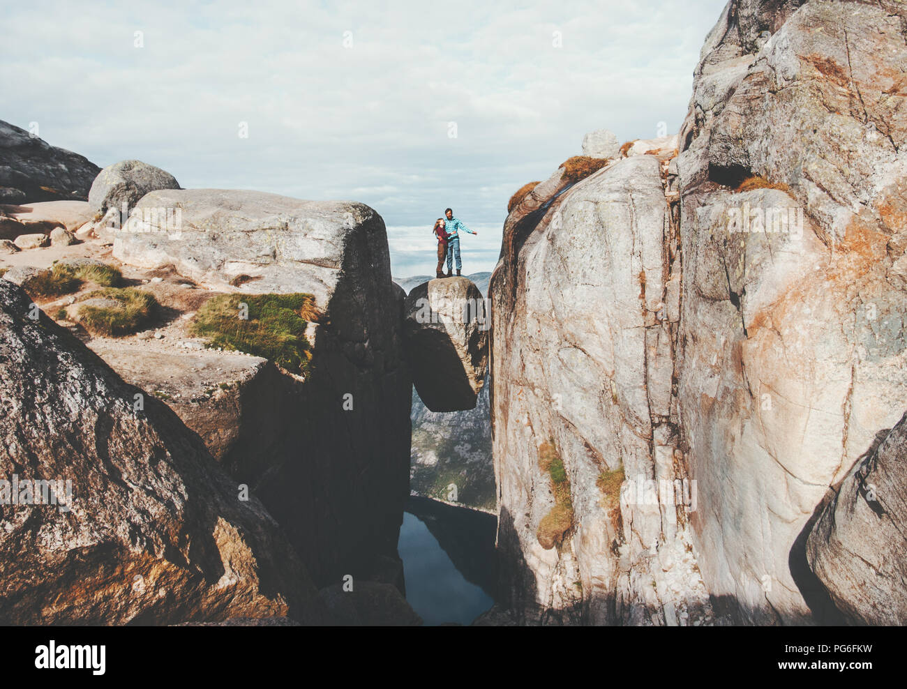 Giovane turisti su Kjeragbolten viaggiando in Norvegia Kjerag montagna Vacanze Avventura famiglia lifestyle l uomo e la donna insieme permanente sulla scommessa di pietra Foto Stock