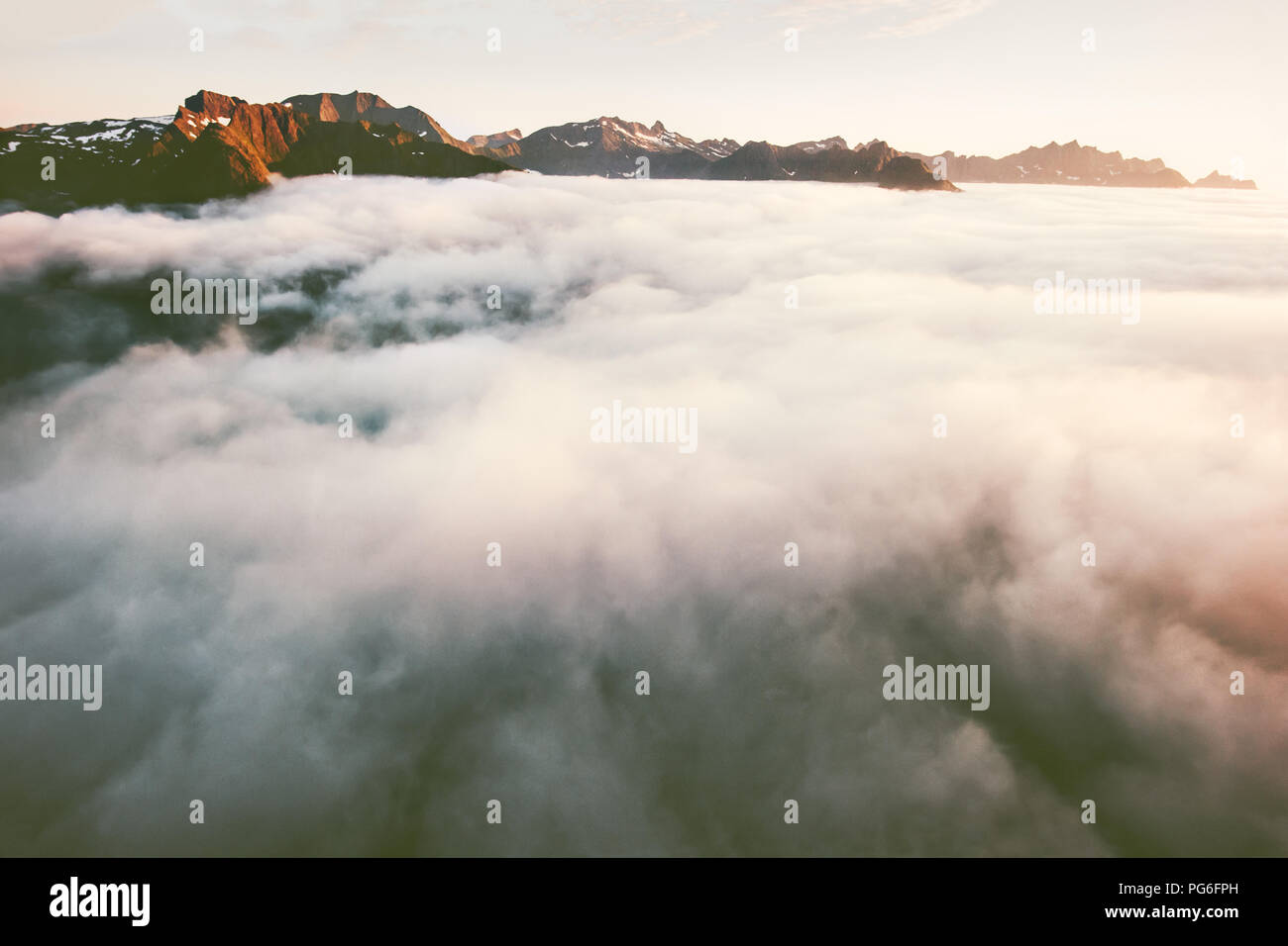 Vista montagne sopra le nuvole paesaggio di rocce al tramonto in Norvegia viaggio scenario dell'antenna Foto Stock