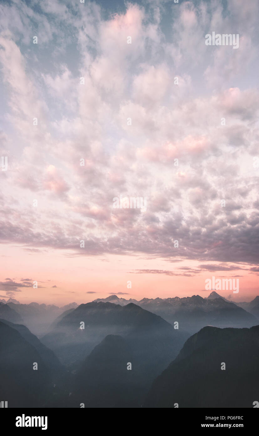 Cielo di tramonto nuvole sopra le montagne dei picchi di gamma paesaggio destinazioni di viaggio natura selvaggia scenic vista aerea Foto Stock
