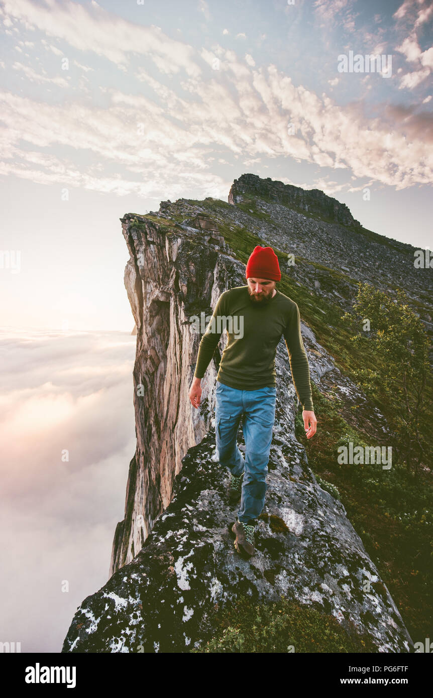 Uomo che cammina da solo sul bordo montagna cresta sopra le nuvole viaggi avventura estrema lifestyle Vacanze di escursioni Foto Stock