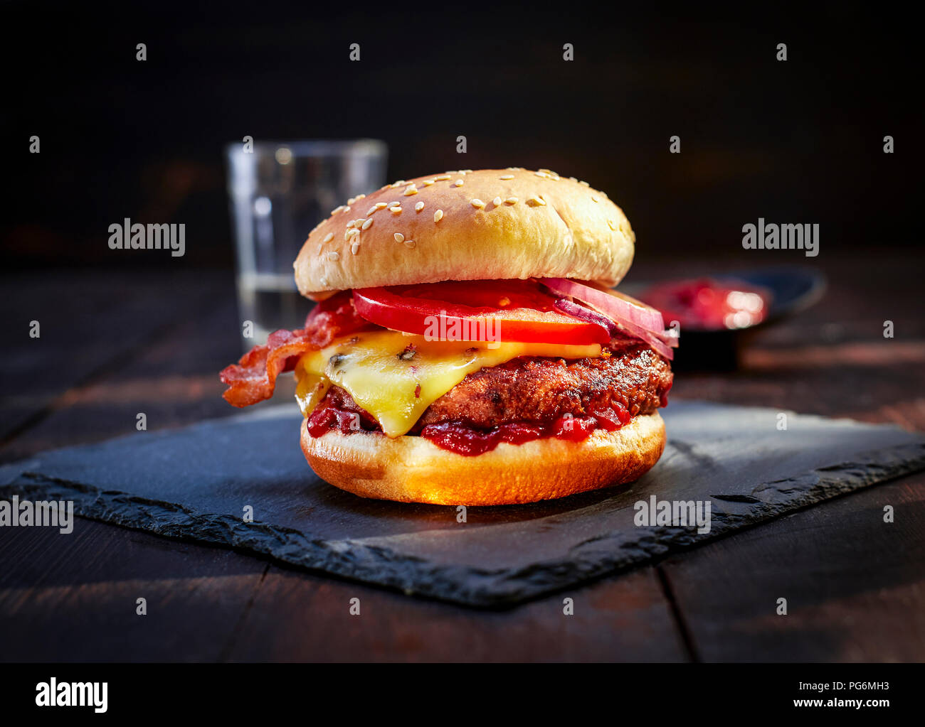 Cheeseburger con bacon sull'ardesia Foto Stock