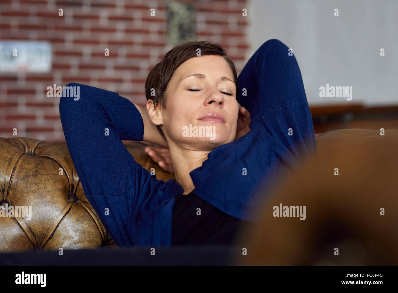 Donna sul divano in un momento di relax a casa Foto Stock