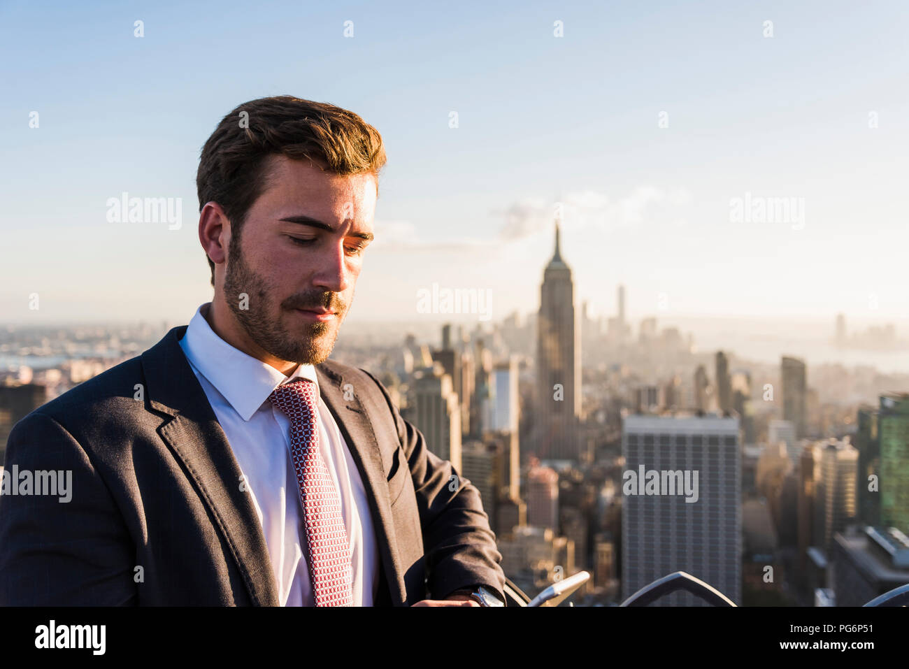 Stati Uniti d'America, New York City, imprenditore con cellulare sul Rockefeller Center observation deck Foto Stock