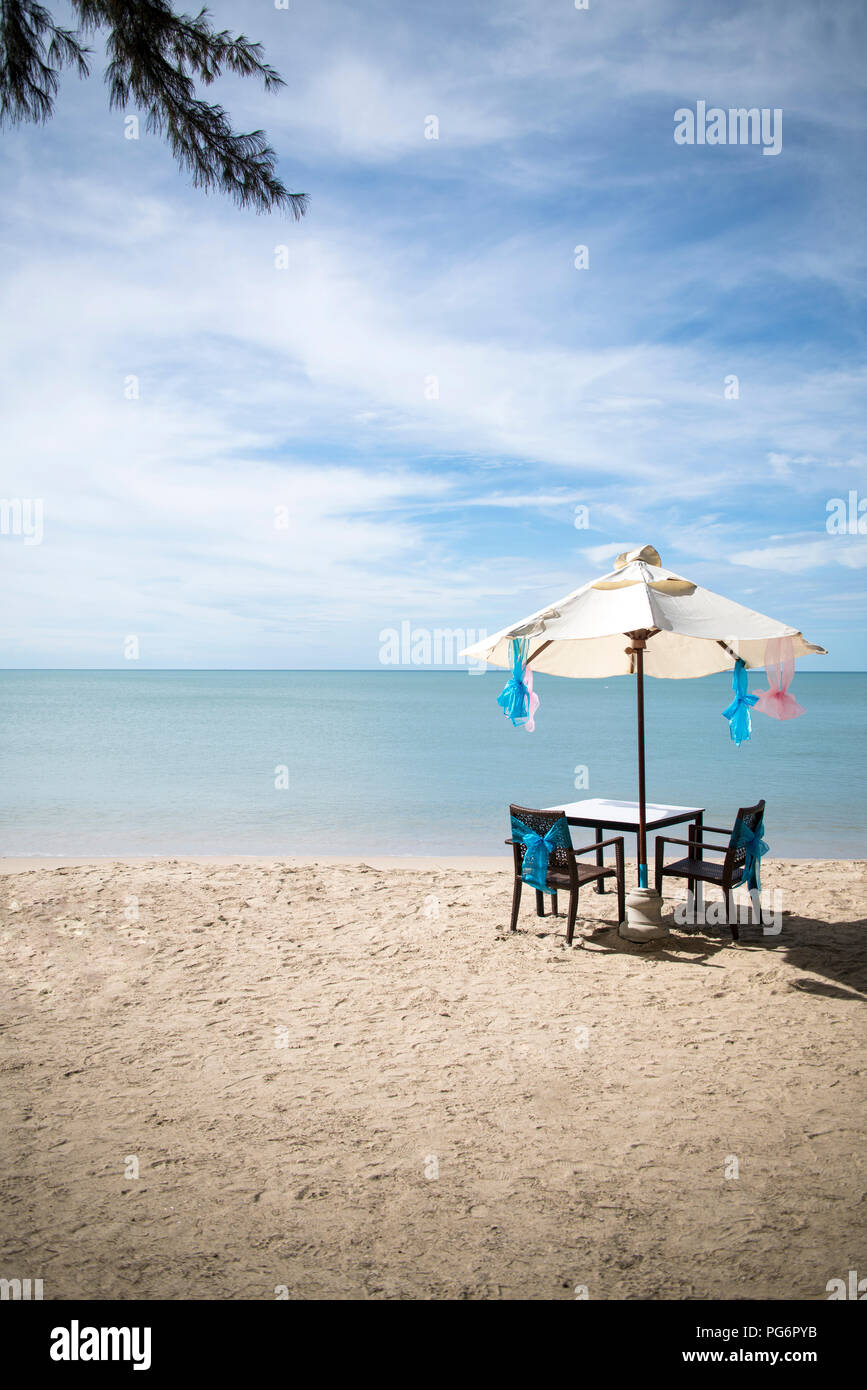 Thailandia, Khao Lak, tavolo, sedie e ombrellone al mare Foto Stock