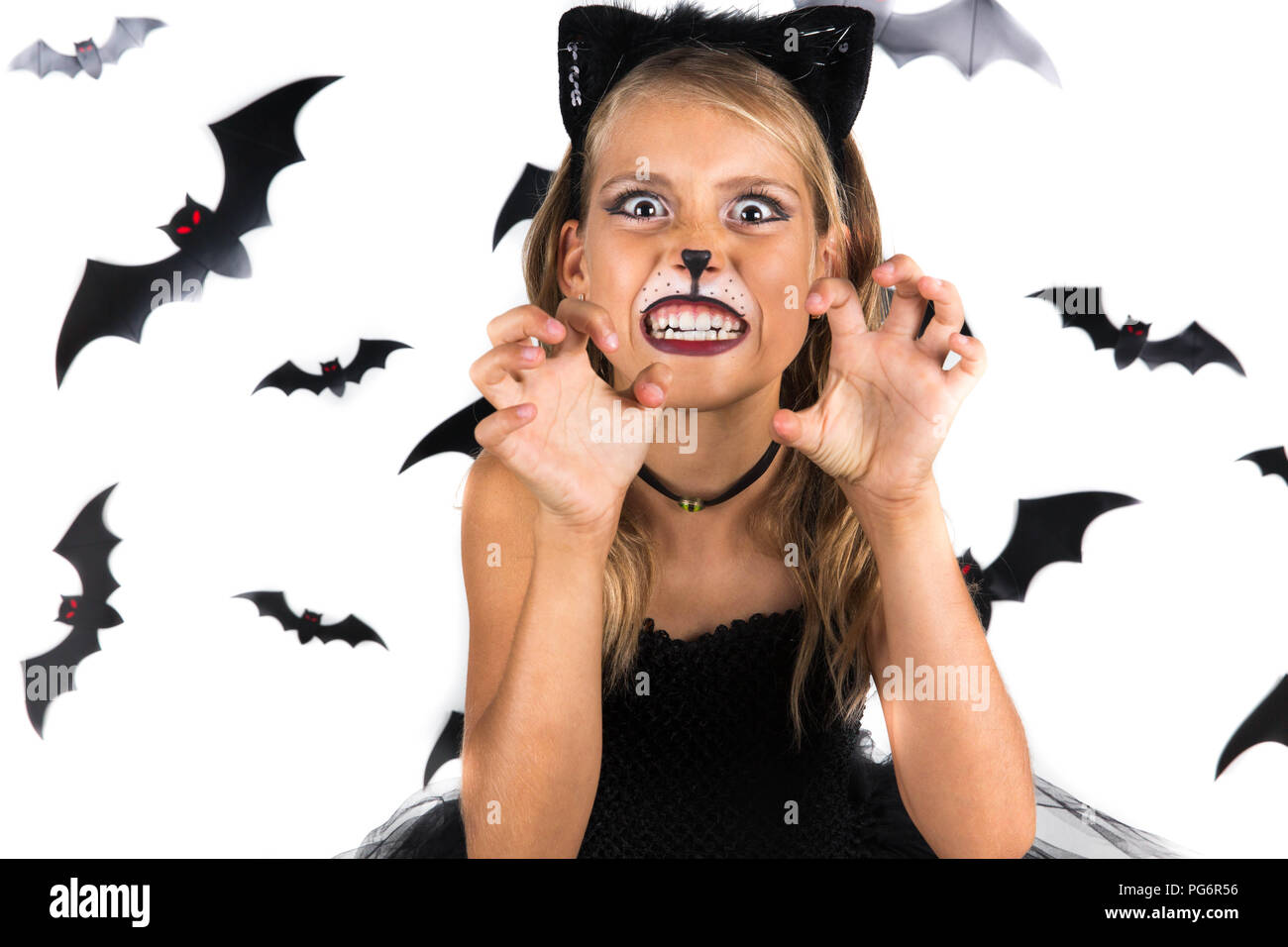 Spooky Ragazza di Halloween con Halloween costume di un gatto nero vestita a festa di Halloween o zucca patch. I bambini di Halloween. Foto Stock