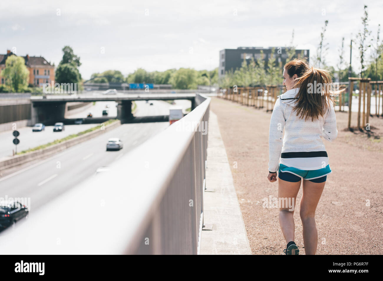 Attività sportive giovane donna camminare accanto all'autostrada Foto Stock