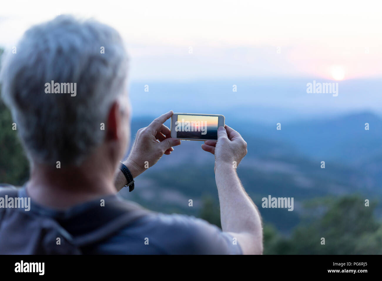 In Spagna, in Catalogna, l uomo a scattare foto di Montserrat al tramonto Foto Stock