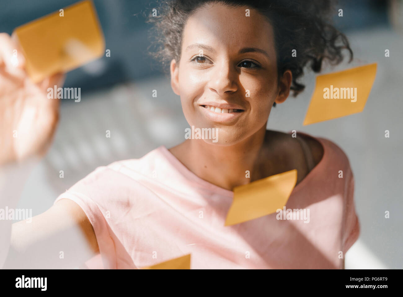 Il brainstorming di donna in office usine note adesive Foto Stock