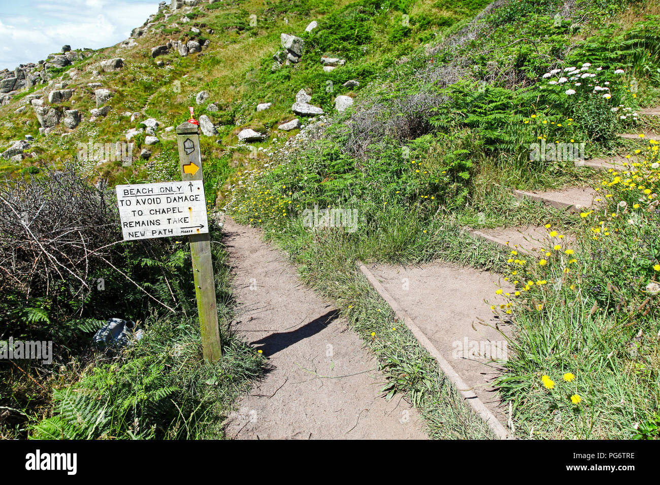 Un cartello che diceva "per evitare danni alla cappella resta prendere il nuovo percorso e passi sopra la cappella Porth Beach vicino a San Levan, Cornwall, South West England, Regno Unito Foto Stock