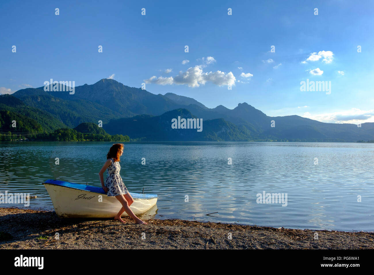 In Germania, in Baviera, Baviera, Heimgarten, ragazza adolescente appoggiata sulla barca al Kochelsee Foto Stock