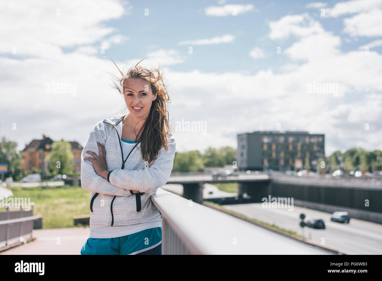 Ritratto di sorridere sportive giovane donna in autostrada Foto Stock