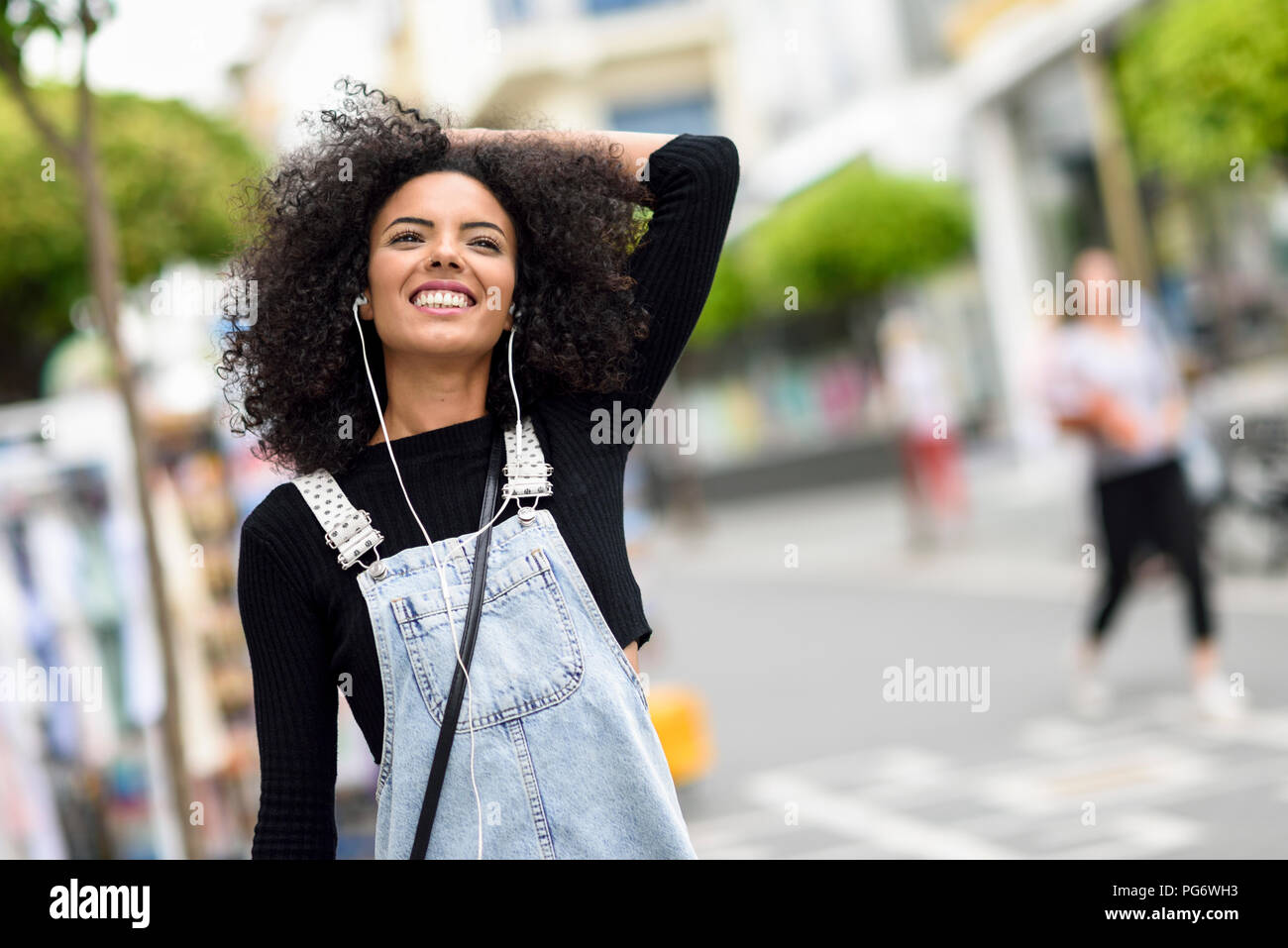 Ritratto di felice giovane donna ascoltando la musica con gli auricolari Foto Stock
