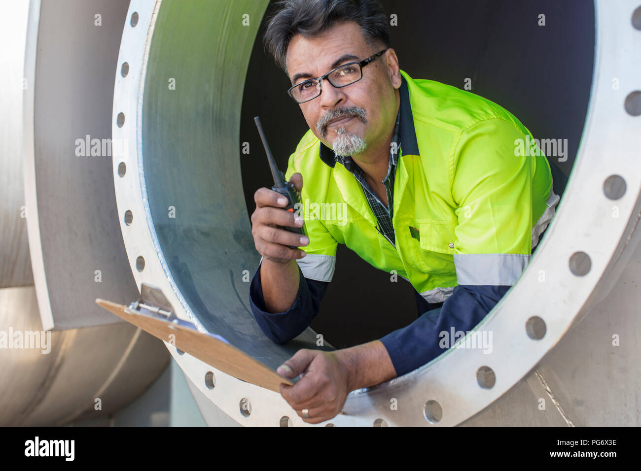 Lavoratore in una vasca utilizzando walkie-talkie Foto Stock