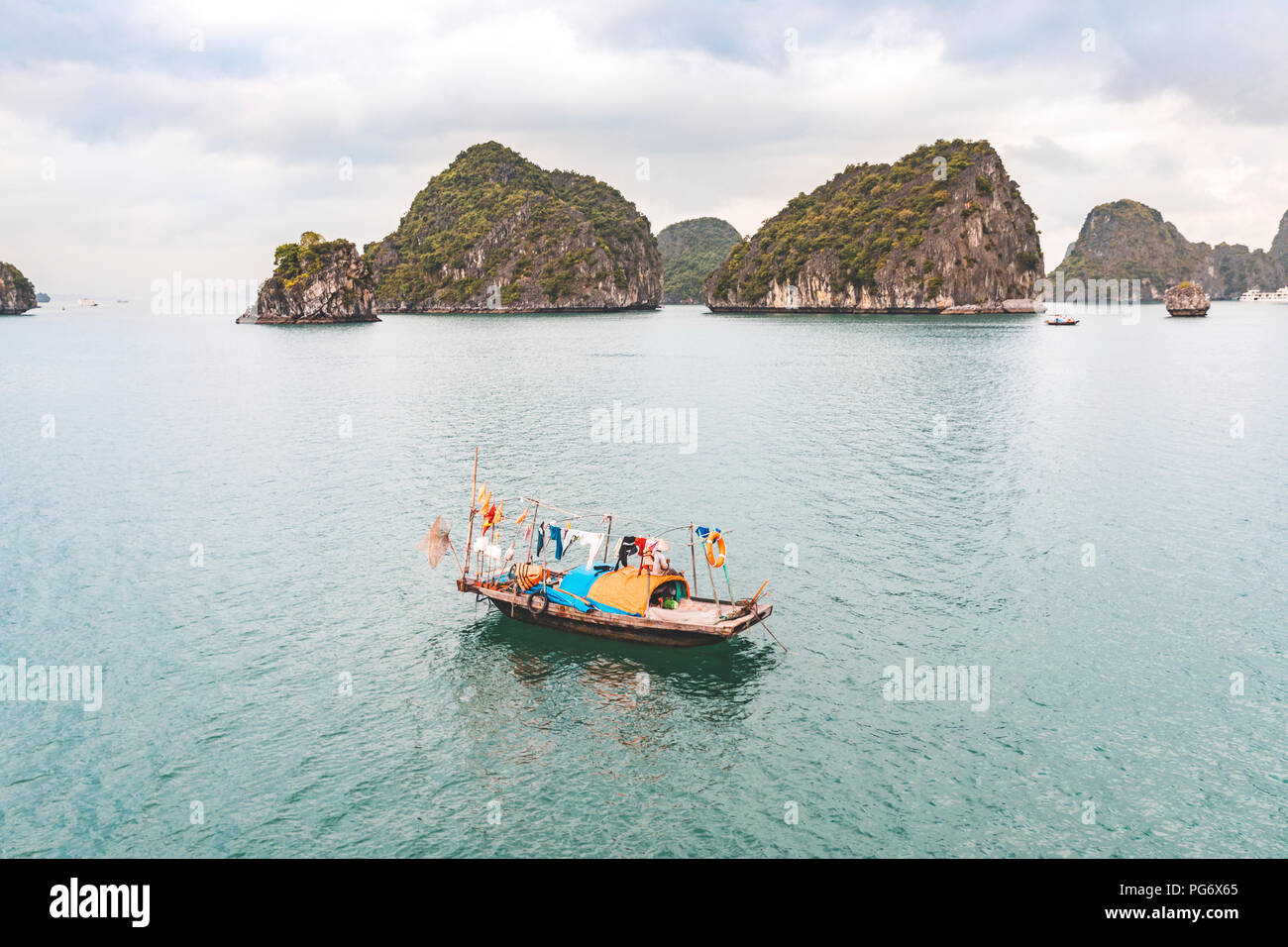 Il Vietnam, la baia di Ha Long, con isole calcaree e piccola barca Foto Stock