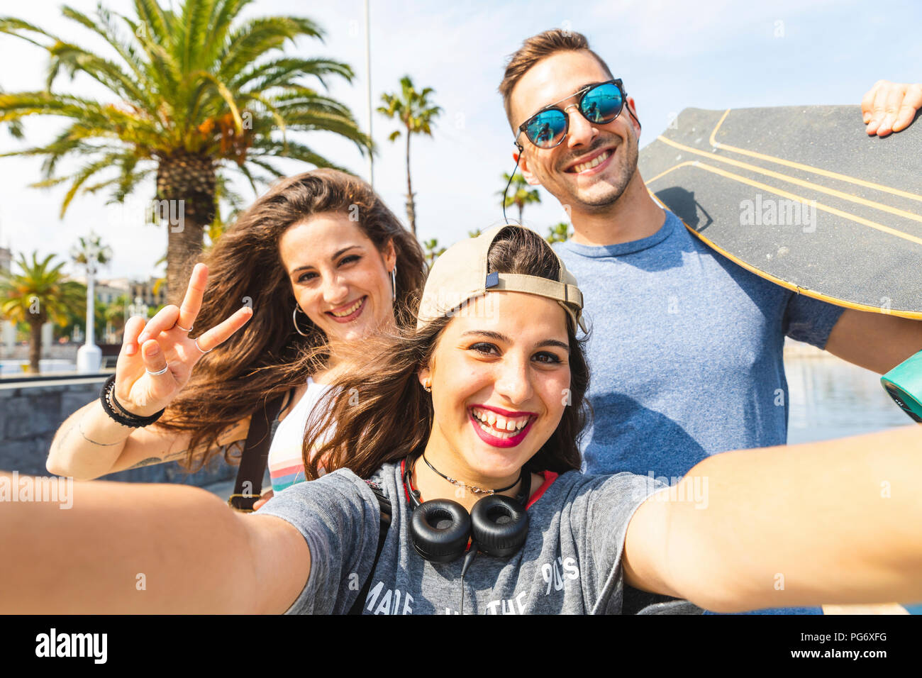 Selfie di tre amici felici con lo skateboard Foto Stock