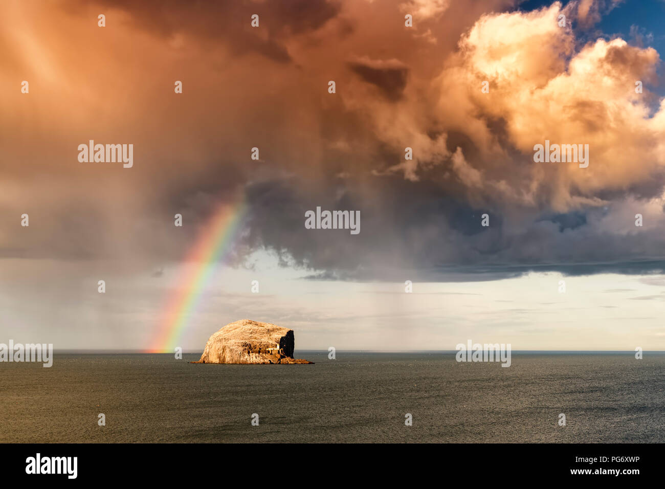Regno Unito, Scozia, East Lothian, North Berwick, Firth of Forth, vista di Bass Rock (famosa in tutto il mondo Gannet Colonia) con arcobaleno e nuvole di tempesta Foto Stock