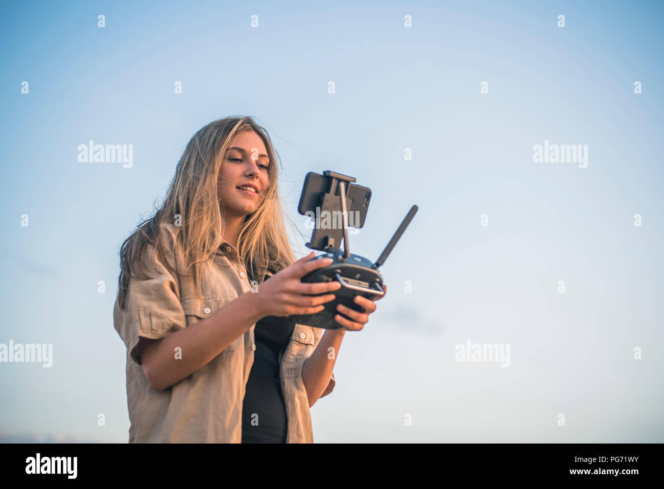 Giovane donna nel paese lato utilizzando un drone Foto Stock