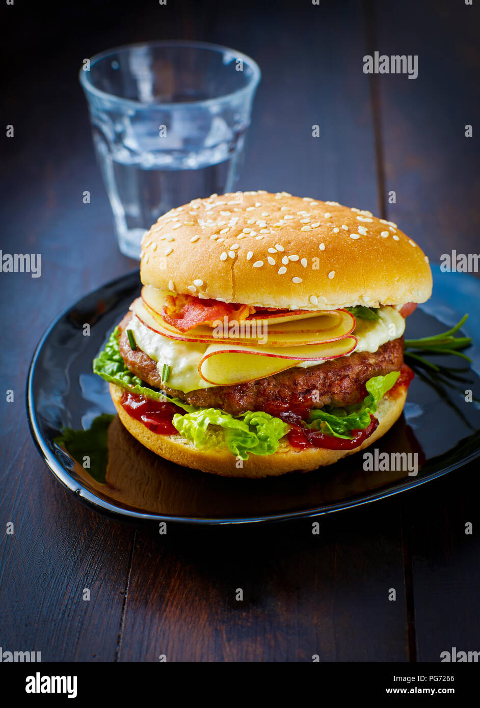 Cheeseburger con Apple e la pancetta sulla piastra Foto Stock