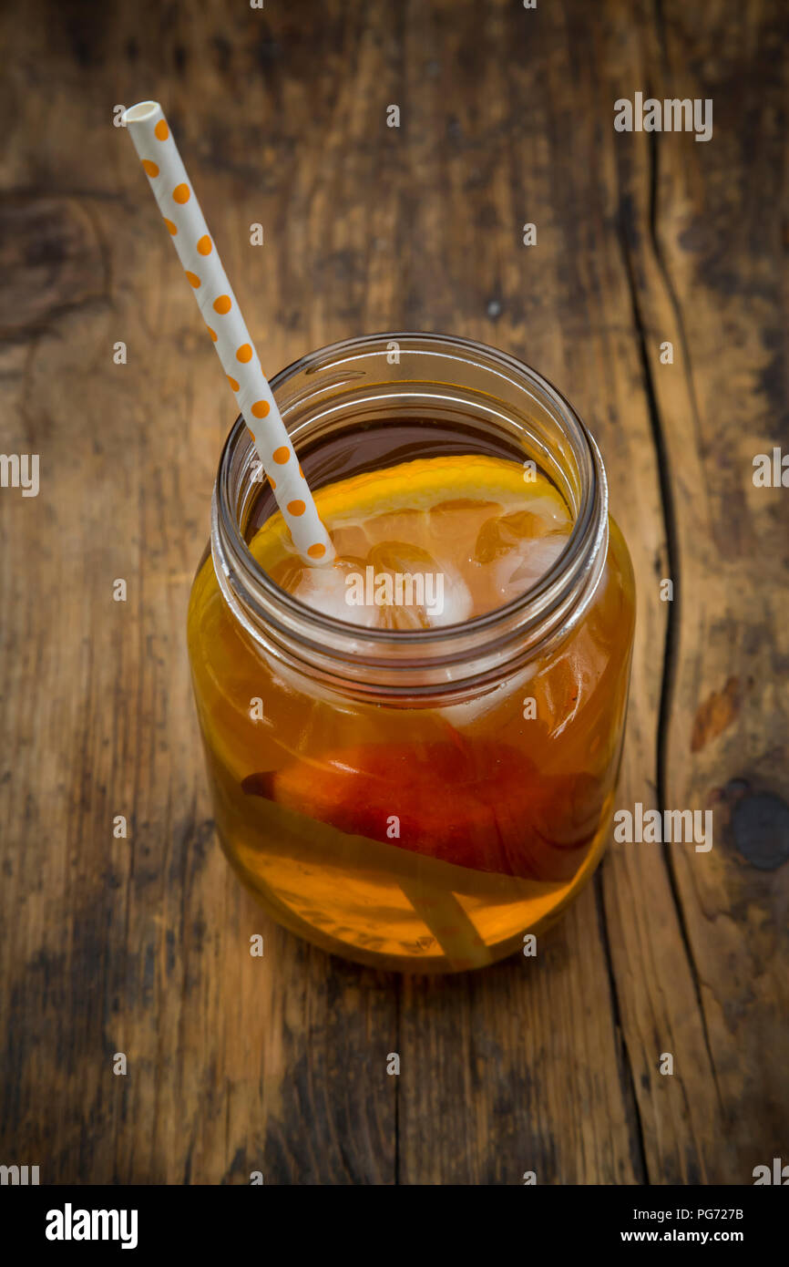 Bicchiere di peach orange ice tea su legno Foto Stock