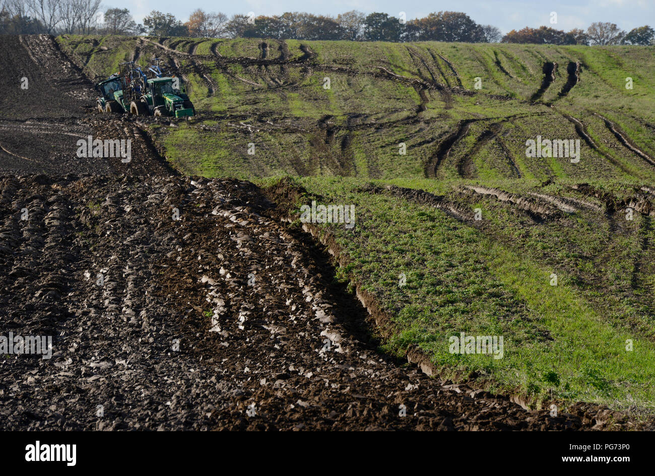 Germania, agricoltura con estrema condizioni di terreno bagnato dopo la pioggia pesante per giorni, due grandi trattori John Deere arenati nel solco Foto Stock