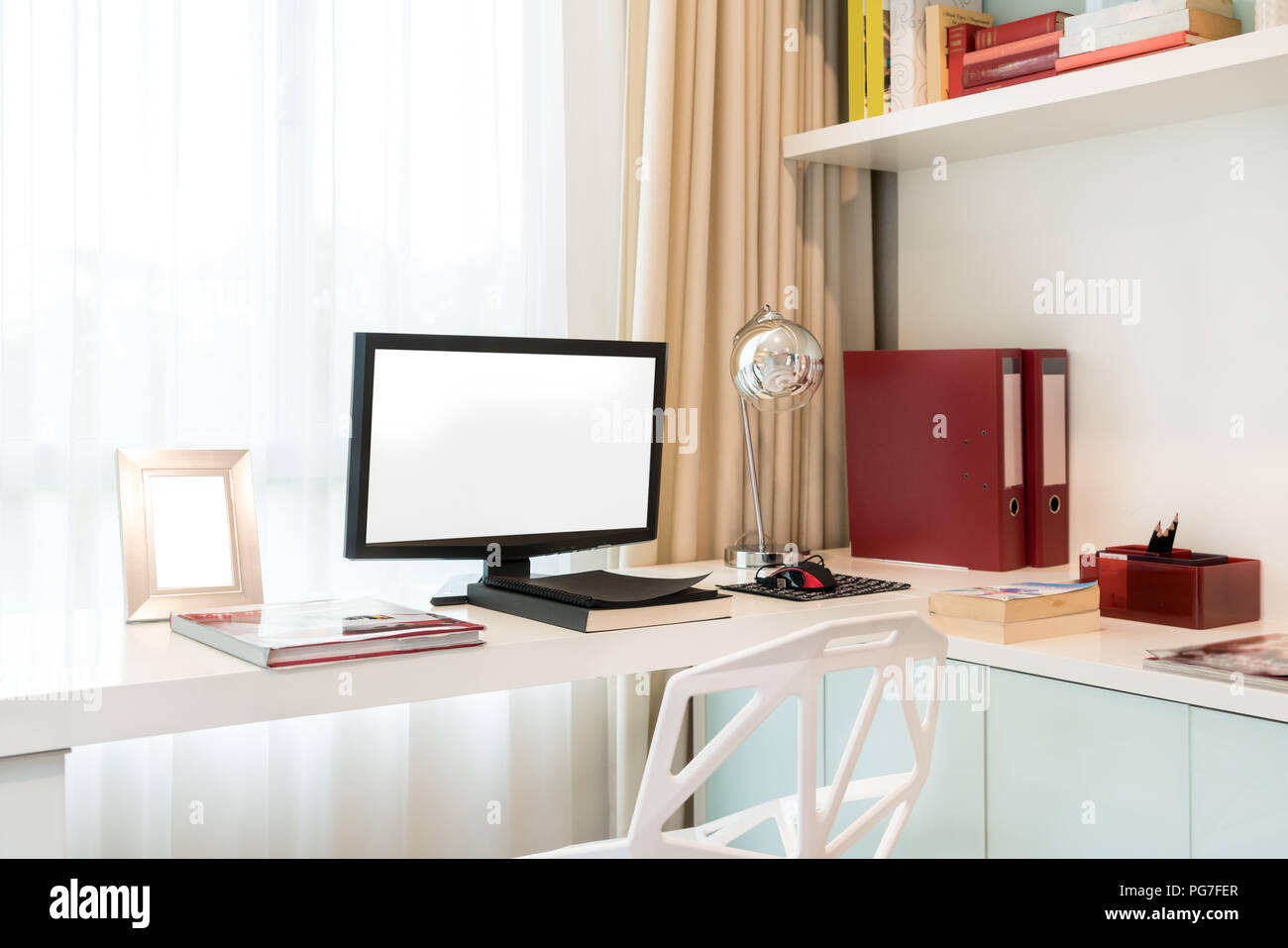 Il display del computer e gli strumenti di office sulla scrivania in casa. Computer desktop isolato sullo schermo. Moderna area di lavoro creativo dello sfondo. Spazio di lavoro a casa. Foto Stock