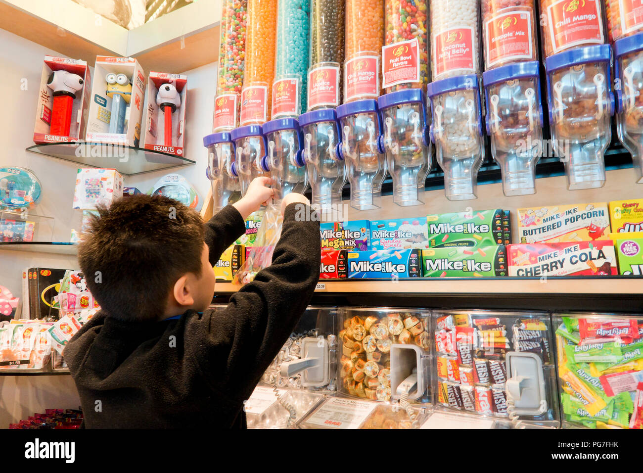 Bambino di età compresa tra i 8 e acquisto di jellybeans presso un negozio di caramelle (sweet shop) - USA Foto Stock