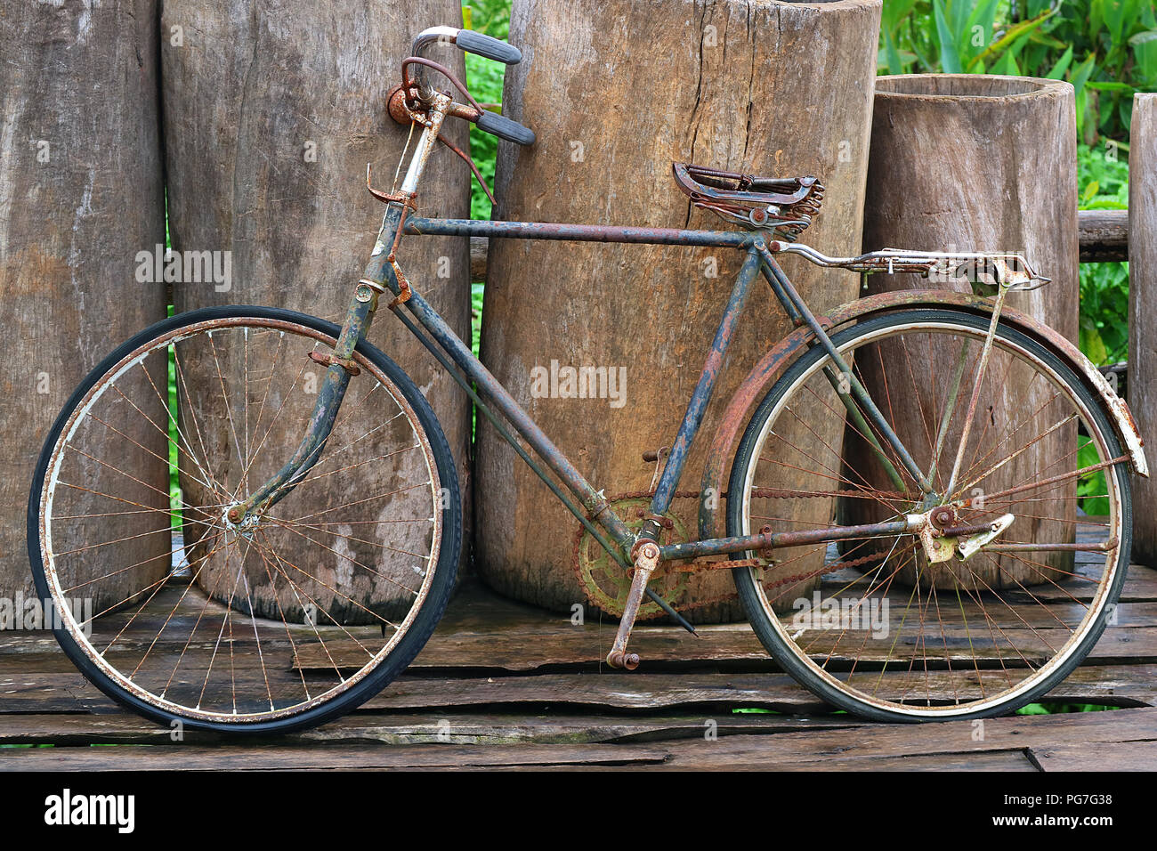 Un vecchio retrò vintage antichi bicicletta appoggiata contro la recinzione  di legno Foto stock - Alamy