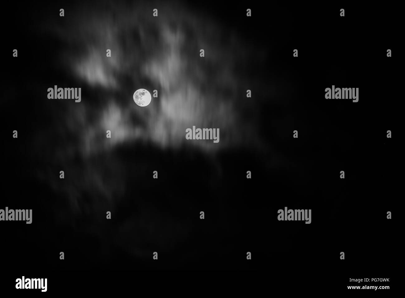 Luna piena nel mezzo di nuvole Foto Stock