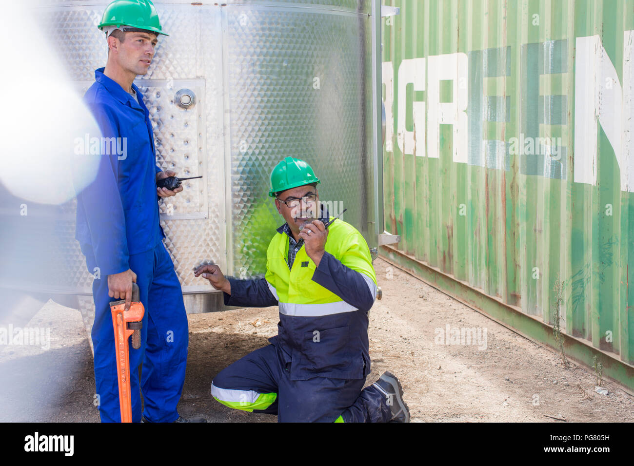 Due lavoratori a un contenitore con walkie talkie Foto Stock