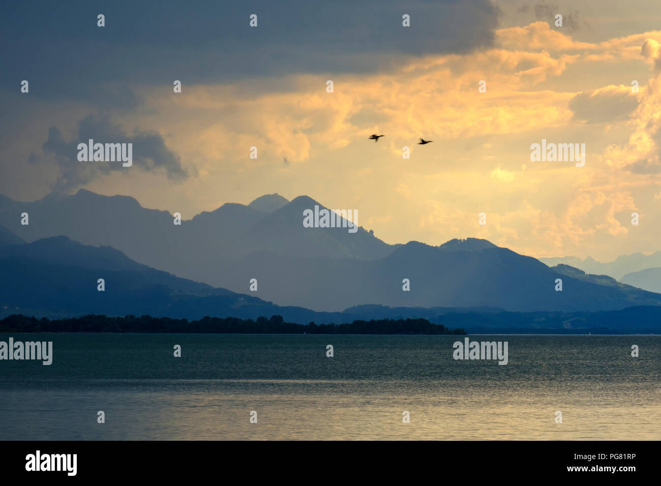 In Germania, in Baviera, Chiemgau Alpi, Chieming a Chiemsee, nuvole scure sul lago Chiemsee Foto Stock