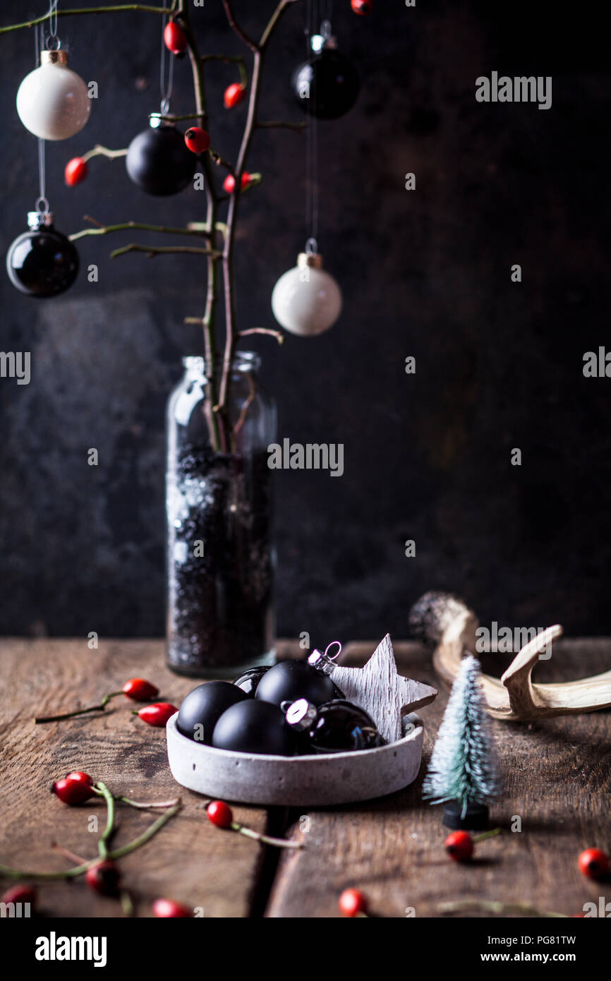 Decorazione Vhristmas con il bianco e nero e baubles ramoscelli con rosa canina in un vaso Foto Stock