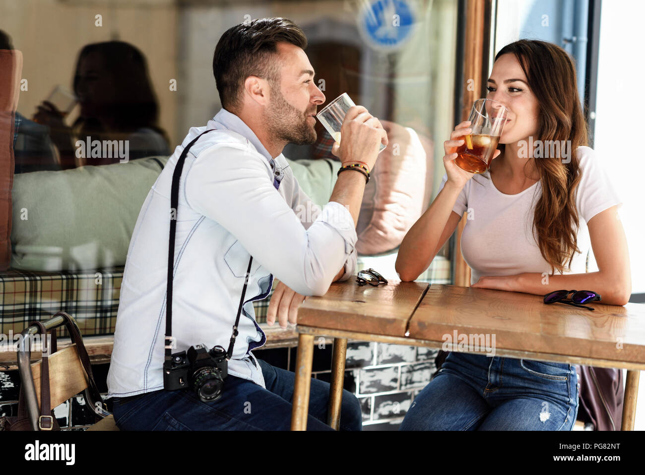Coppia avente un drink in un bar all'aperto nella città Foto Stock